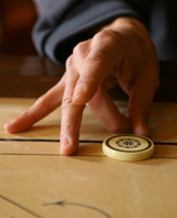 Le tir avec le majeur au carrom Le tir avec le majeur au carrom